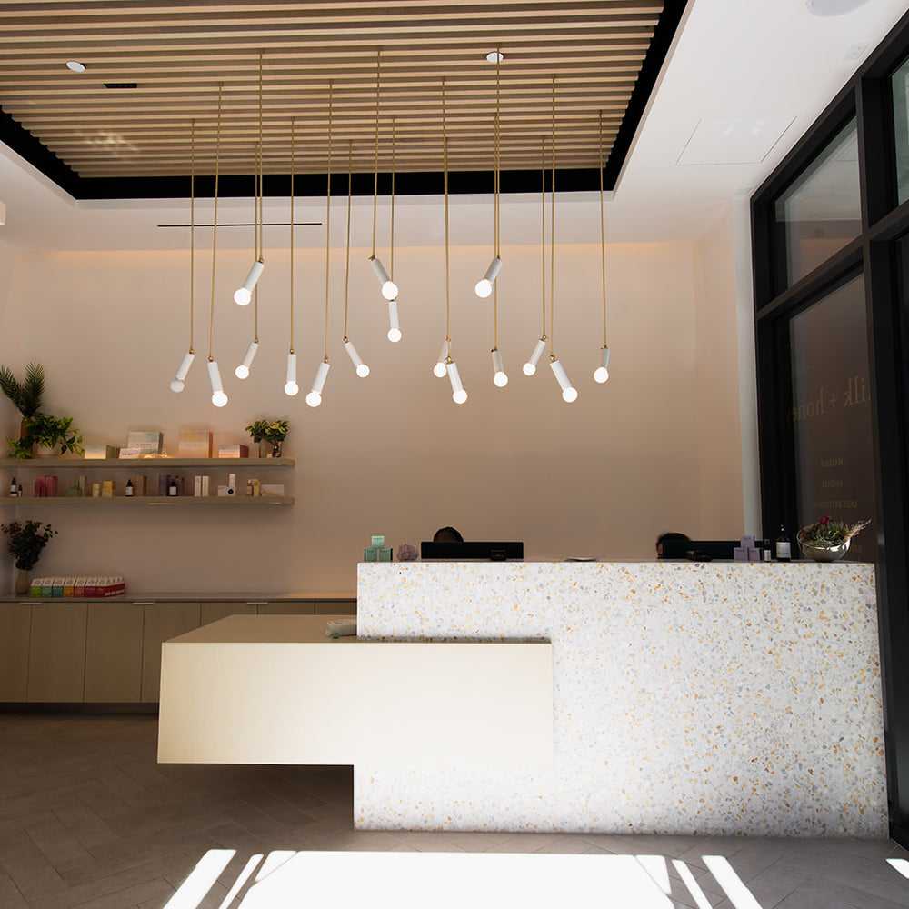 Modern interior of a store with a reception desk and decorative lights.