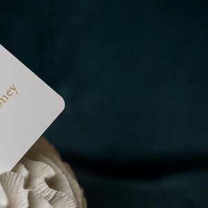 Card with 'milk honey' branding on a textured surface against a dark background