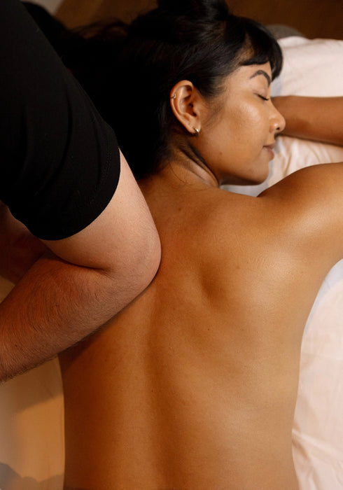 Person receiving a back massage in a bedroom setting