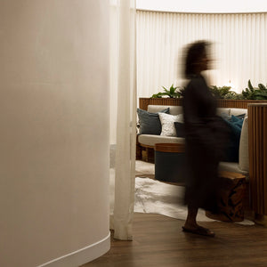 Person walking through a modern living room with neutral tones