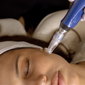 Person receiving a facial treatment with a blue device on their face.