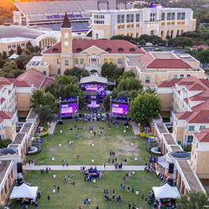 Aerial view of a university campus with a large gathering in the center.