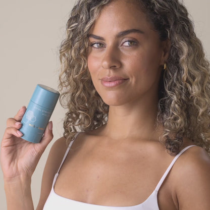 Woman smiling while holding milk+honey Number 9 product.